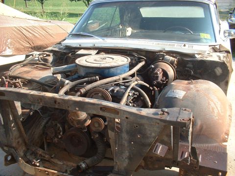 1967 Ford Galaxie - The engine bay of a 1967 Ford Galaxie shows a V8 engine and significant rust on the front structure.