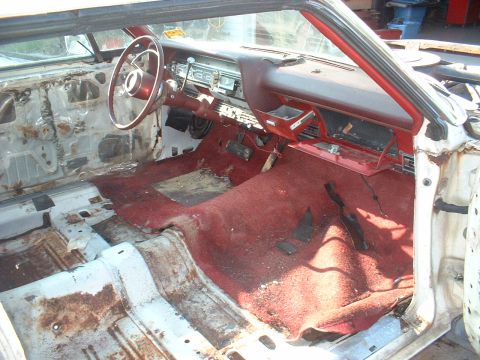 1967 Ford Galaxie - Interior view of a 1967 Ford Galaxie, showing red carpet and stripped door panels.