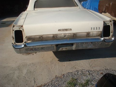 1967 Ford Galaxie - Rear view of a white 1967 Ford Galaxie convertible undergoing restoration, showing missing taillights and a chrome bumper.