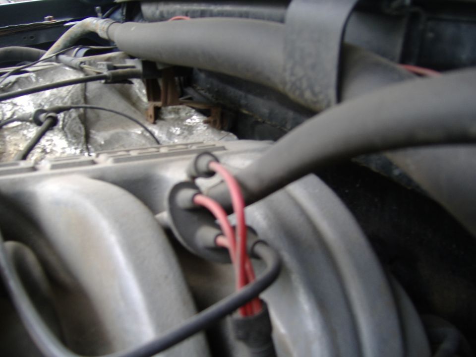 Engine intake manifold with red spark plug wires and hoses