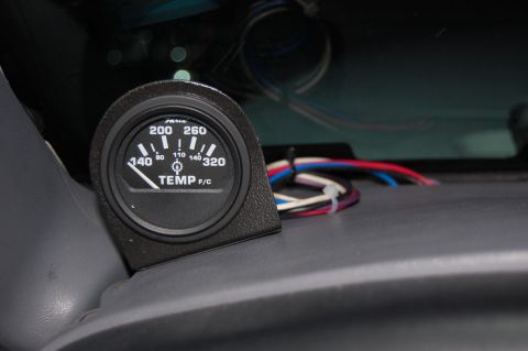 1994 Ford Bronco - Close-up of an aftermarket temperature gauge and its wiring, likely installed in a vehicle's interior.