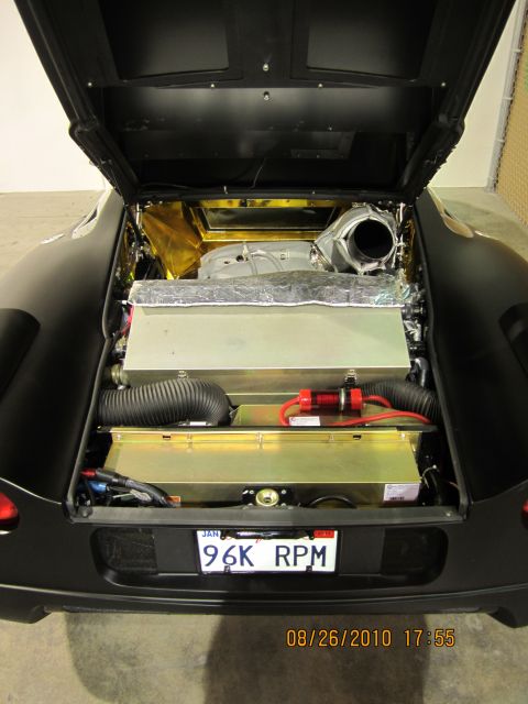 1996 Ford Bronco - Rear view of a black car's engine compartment, showing various components and a license plate.
