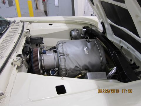 1996 Ford Bronco - The engine bay of a vehicle, a prominent, insulated engine component and an air filter, photographed on August 26, 2010.