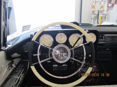 1996 Ford Bronco - The dashboard of a classic car features a two-tone steering wheel and several analog gauges.