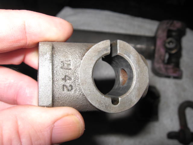 Hand holding a cast metal clamp collar with keyed bore, stamped W 42