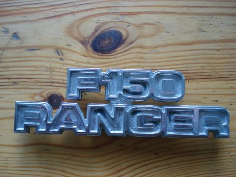 1979 Ford F-150 - F150 and Ranger emblems are shown on a wooden background.