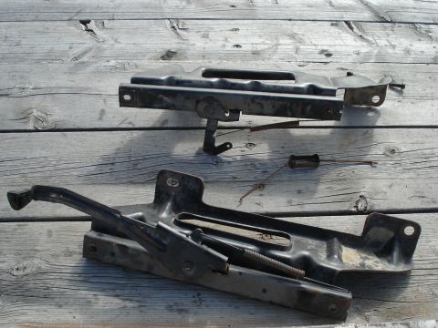 1979 Ford Bronco - Car jack and mounting bracket components are laid out on a weathered wooden surface.