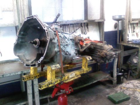 1990 Ford Bronco - Transmission assembly is mounted on a stand in a workshop environment.