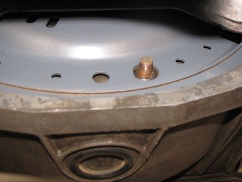 1994 Ford Bronco - A close-up view shows a bolt on a gray metal surface with several holes, with the Supermotors.net logo in the corner.