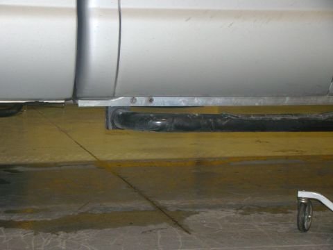 2008 Ford F-250 - Close-up of a truck's side panel and running board, showing a black pipe below.