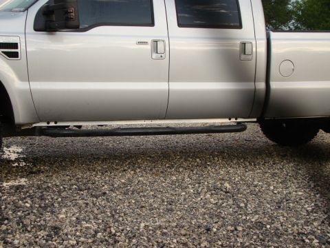 2008 Ford F-250 - The side profile of a silver pickup truck is shown, running boards and a gravel surface below.