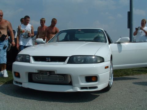 1993 Ford Taurus - A white coupe with an aftermarket intercooler and GT-R badging is displayed at an outdoor event.