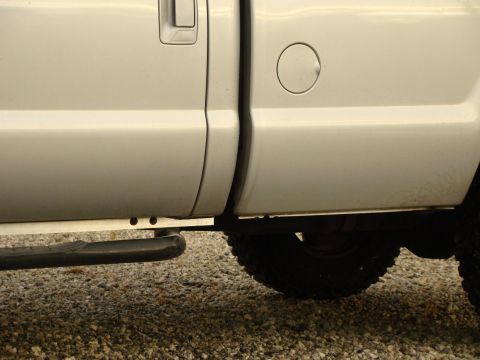 2008 Ford F-250 - Side view of a silver pickup truck, focusing on the lower body panels and running board.