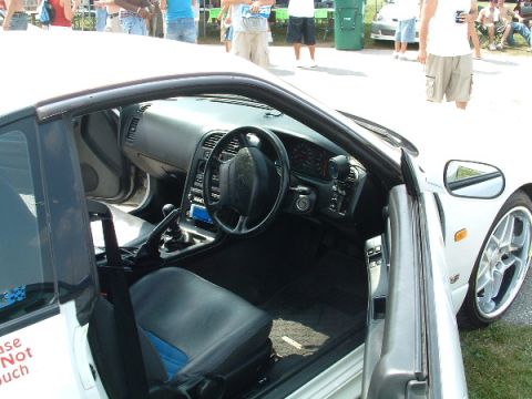 1993 Ford Taurus - The interior of a white sports car is visible, blue accents on the seats and a black steering wheel.