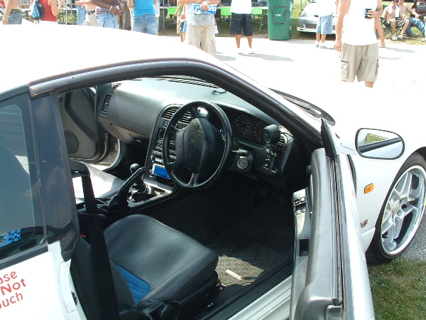 Interior of white sports car with blue accents on seats and a black steering wheel