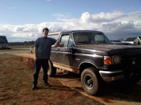 1990 Ford Bronco - A man poses with a black 1990 Ford Bronco, which appears to be a fourth-generation model.