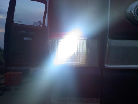 1990 Ford Bronco - The bright tail light of a 1990 Ford Bronco is illuminated, showing its rear quarter panel and door.