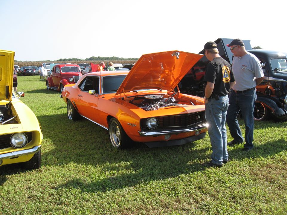 Orange 1969 Chevrolet Camaro with hood open, viewed from front-right