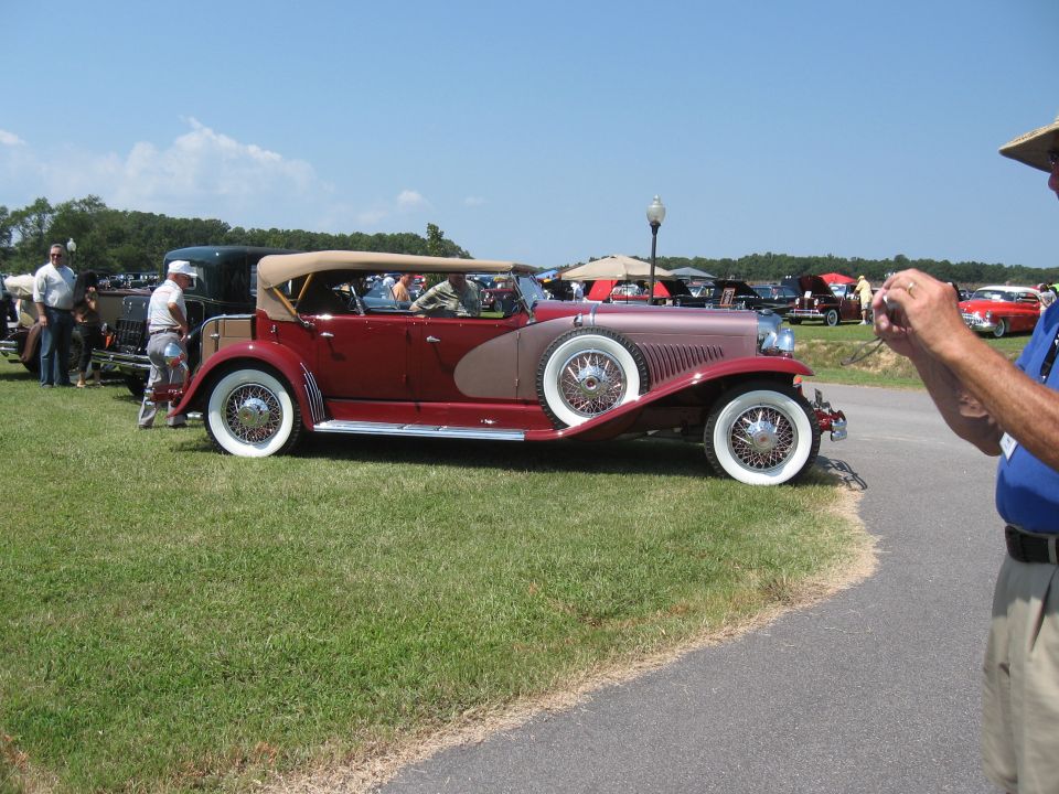 Two-tone red and tan convertible with a tan top and whitewall tires, seen from the side