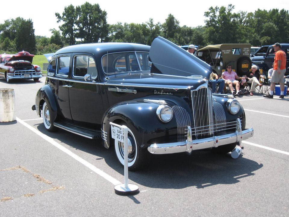 Black sedan with hood up at a car show. Sign says 'Class 1 20 F1'