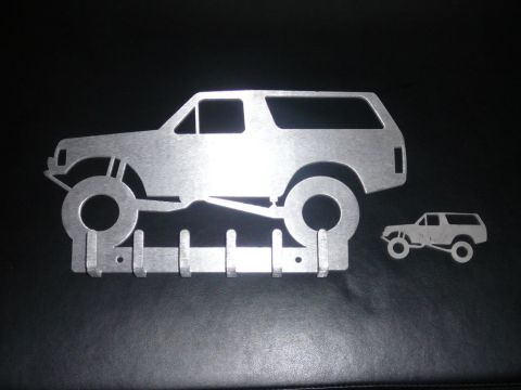 1988 Ford Bronco - This metal wall art features a silhouette of a lifted SUV, possibly a Bronco, with hooks below.