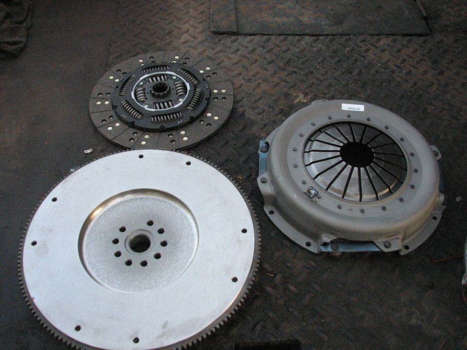 Clutch disc, pressure plate, and flywheel assembly on a dark floor