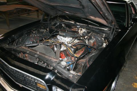 1973 Ford Ranchero - The engine bay of a 1973 Ford Ranchero is shown with the hood open, revealing the engine and surrounding components.