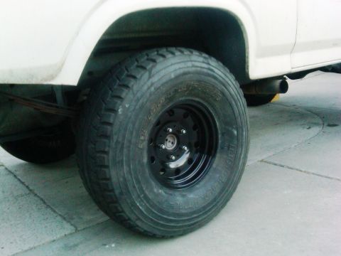 1986 Ford Bronco - A close-up view of the rear tire and exhaust system of a vehicle.