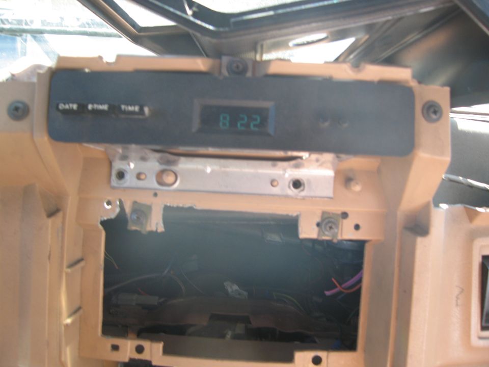 Dashboard clock display showing 8:22, with exposed wiring below