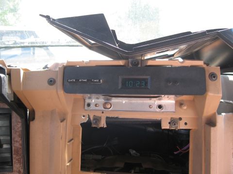 1986 Ford Bronco - Interior view of a car's dashboard showing a digital clock and surrounding trim.