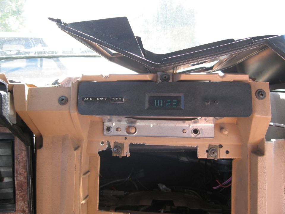 Car dashboard with clock showing 10:23 and buttons labeled DATE, TIME
