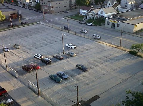 2003 Ford Crown Victoria - A white 2003 Ford Crown Victoria is visible in a parking lot with several other vehicles.