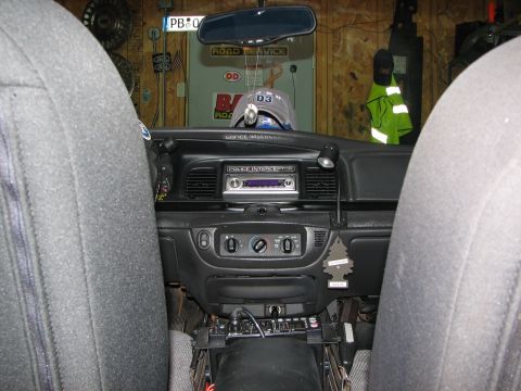 2003 Ford Crown Victoria - The dashboard of a police car shows a radio, climate controls, and a police interceptor label.
