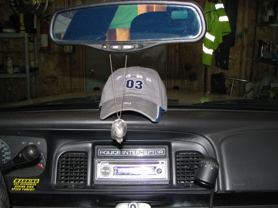 Ford Crown Victoria interior with a gray Ford 03 hat hanging from the rearview mirror