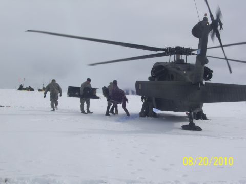 1990 Chevrolet Suburban - Personnel unload cargo from a dark helicopter on a snowy plain, with the date 08/20/2010 visible.