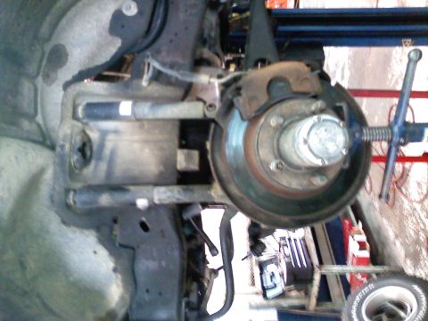 1990 Ford Bronco - Vehicle's front suspension and brake assembly, likely undergoing maintenance or repair.