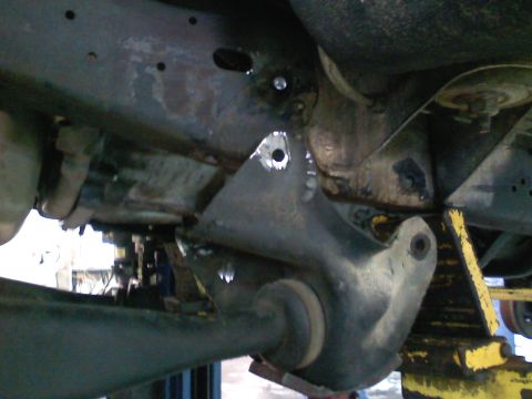 1990 Ford Bronco - Close-up view of the vehicle's undercarriage, focusing on the frame and suspension system with a visible SuperMotors watermark.