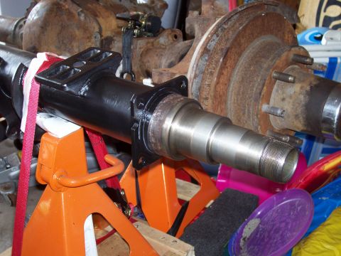 1994 Ford Bronco - Close-up of a vehicle axle part, showing the spindle and brake rotor assembly.