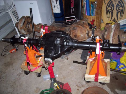 1994 Ford Bronco - Two Ford Bronco rear axles are shown, one freshly painted black and the other showing significant rust.