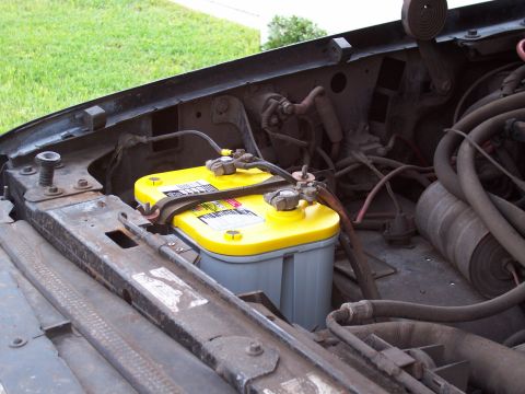 1994 Ford Bronco - Close-up of a yellow top battery in the engine bay of a vehicle.