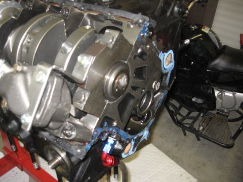 1965 Ford Fairlane - Close-up of an engine block and crankshaft, with a motorcycle in the background.