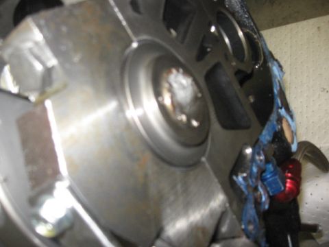 1965 Ford Fairlane - Detail of an engine's crankshaft seal housing, showing a close-up of the metal components and blue sealant application.