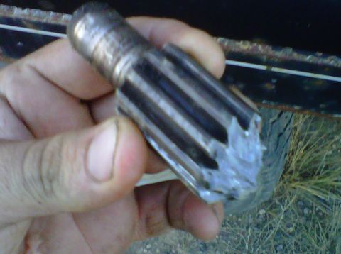 1977 Ford F-250 - A damaged metal gear part is held in a hand, showing its splined surface.
