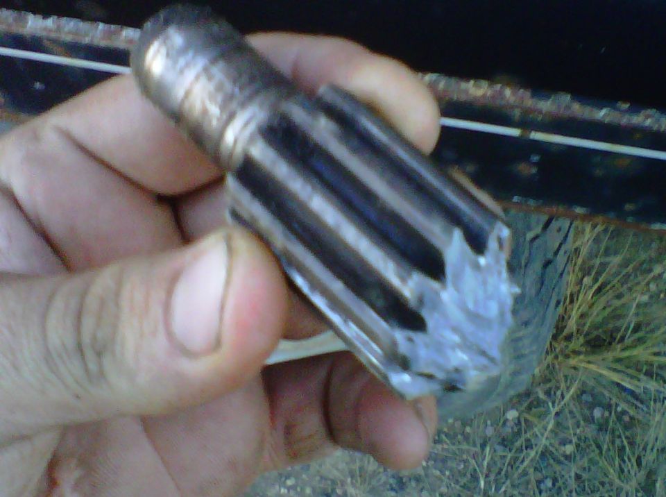 Hand holding a damaged metal gear with splines