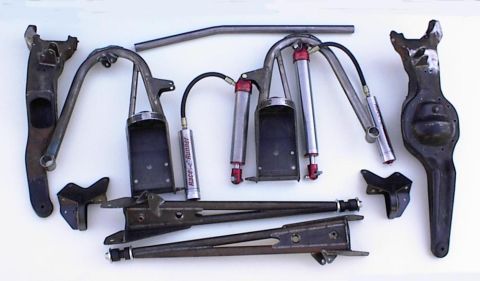 1990 Ford Bronco - Various suspension parts are laid out, including shocks, control arms, and a differential housing, with some components bearing the 'Race-R…