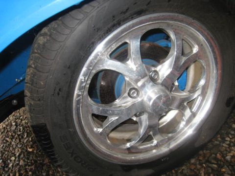 1957 Chevrolet Bel Air - Close-up of a custom chrome wheel and tire on a blue vehicle.