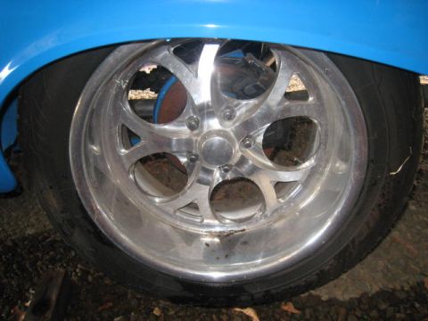 1957 Chevrolet Bel Air - A close-up view of a custom chrome wheel and tire on a blue vehicle.