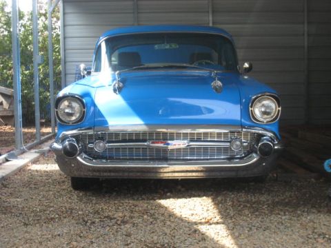 1957 Chevrolet Bel Air - Front view of a blue 1957 Chevrolet Bel Air, showing its distinctive grille and headlights.
