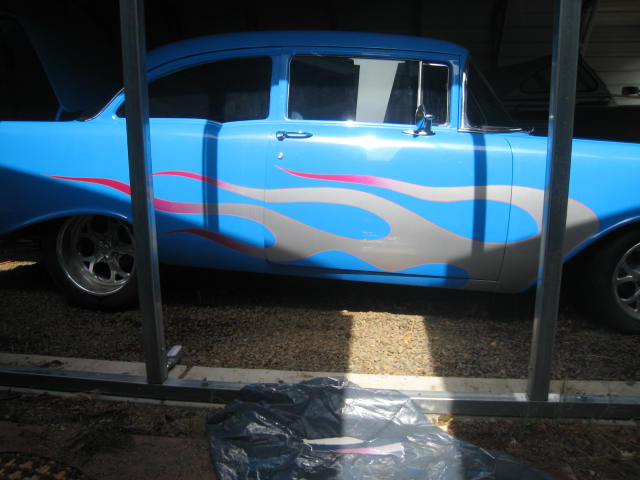 Blue 1957 Chevrolet Bel Air sedan with silver and pink flame graphics on the side