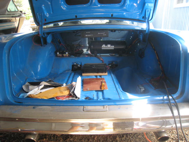 Trunk of a 1957 Chevrolet Bel Air with blue interior and air suspension parts installed
